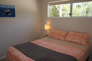 a bedroom with a bed and a window at Sapphire Chalets, Augusta in Augusta