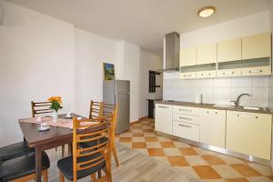 a kitchen with a table and chairs in a room at Apartman Petra in Fažana