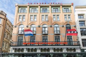 um edifício com duas bandeiras na frente em Hotel Amsterdam De Roode Leeuw em Amsterdã