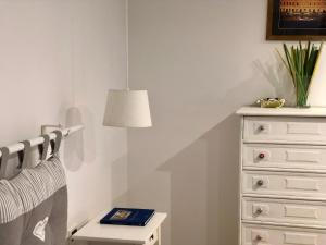 ジェノヴァにあるI Rolli a Genovaのベッドルーム1室(ランプとドレッサー付きのベッド1台付)