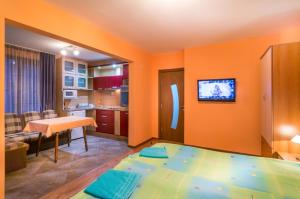 a living room with orange walls and a kitchen at Guest House Karamihalevi in Sozopol