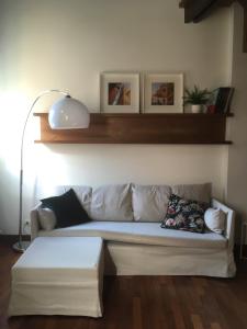 ein weißes Sofa im Wohnzimmer mit Lampe in der Unterkunft Casa Falegnami 20.19 in Bologna