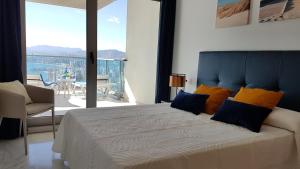 una camera da letto con un grande letto con una grande finestra di Two-bedroom Apartment with Sea Views - Torre Lugano 29 a Benidorm