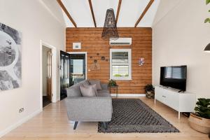 sala de estar con sofá y TV en Geelong West Miner's Cottage, en Geelong
