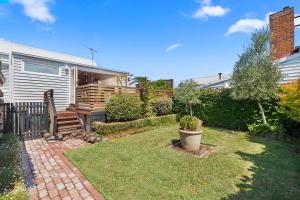 a small yard with a house and a garden at Geelong West Miner's Cottage in Geelong