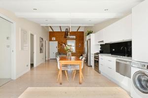 a kitchen with a wooden table and a dining room at Geelong West Miner's Cottage in Geelong