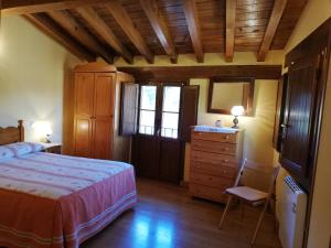 een slaapkamer met een bed, een dressoir en een spiegel bij Casa Rural LA HUERTA DE POTES in Cabezón de Liébana