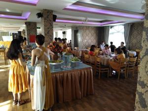 um grupo de pessoas sentadas em mesas em um restaurante em AEC Hotel Ban Me em Buon Ma Thuot