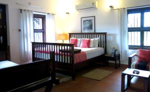 - une chambre avec un lit doté d'oreillers rouges et blancs dans l'établissement Clayfingers Art Cottage, à Thrissur