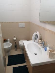 ein Badezimmer mit einem weißen Waschbecken und einem WC in der Unterkunft white house in Bari