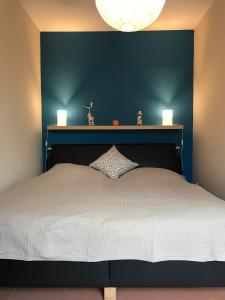 um quarto com uma cama grande e uma parede azul em Ferienwohnung-Strandspaziergang, kleine Wohnung em Börgerende-Rethwisch