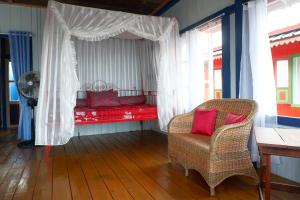 Habitación con 1 cama con silla y ventilador en Rock and Wreck Dive Resort en Tanjungbinga
