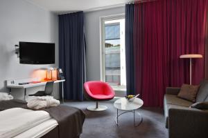 ein Hotelzimmer mit einem Bett und einem roten Stuhl in der Unterkunft Thon Partner Hotel Ullevaal Stadion in Oslo