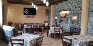 une salle à manger avec des tables, des chaises et une télévision dans l'établissement Agriturismo Il Capitano, à Floresta