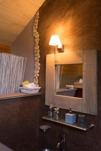 ein Bad mit einem Waschbecken und einem Spiegel in der Unterkunft Gîte de Corbion in Leignon