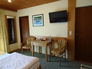 a hotel room with a table and chairs and a television at Pension Friedl in Innsbruck