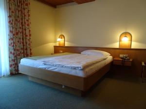 ein Schlafzimmer mit einem Bett mit zwei eingeschalteten Lampen in der Unterkunft Pension Friedl in Innsbruck