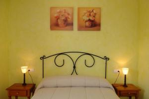a bedroom with a bed with two lamps and two pictures at Casas Rurales El Viejo Establo in Fortuna