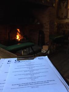 a piece of paper sitting on a table next to a fireplace at The Rose & Crown, Snettisham in Snettisham