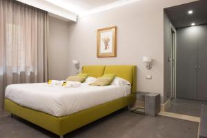 a bedroom with a large bed with a green headboard at Principessa Mafalda in Messina