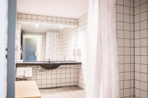 un bagno con lavandino e specchio di Comwell Middelfart a Middelfart