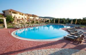 a large pool with lounge chairs and a resort at Aktaion Resort in Gythio