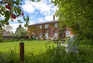 a house with a table in the grass in front of it at Lower Buckton Country House in Leintwardine