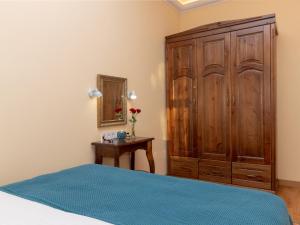 リヴィウにあるLviv Suites at Pidmurna st. 20のベッドルーム1室(大きな木製キャビネット、ベッド1台付)