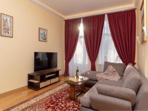 een woonkamer met een bank en een televisie bij Lviv Suites at Pidmurna st. 20 in Lviv