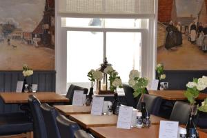 une salle à manger avec des tables et des chaises ainsi qu'une fenêtre dans l'établissement Fletcher Badhotel Egmond aan Zee, à Egmond aan Zee
