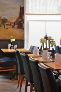 une salle à manger avec des tables, des chaises et un tableau dans l'établissement Fletcher Badhotel Egmond aan Zee, à Egmond aan Zee