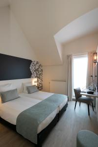 een slaapkamer met een bed, een bureau en een raam bij Martin's Brugge in Brugge