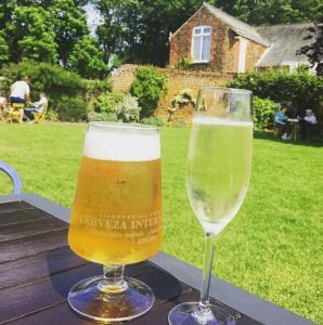 two glasses of beer sitting on top of a table at The Rose & Crown, Snettisham in Snettisham