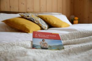 un livre assis au-dessus d'un lit dans l'établissement Casa vacanze Dos de Loré - Relax a due passi da Tovel, à Tuenno