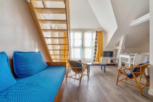 sala de estar con sofá azul y sillas en Residence Saint Goustan - maeva Home, en Le Croisic