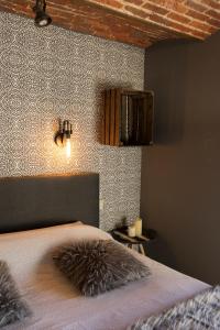 een slaapkamer met een bed en een muur bij Gîte de Corbion loft2 in Ciney