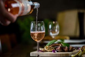 a person pouring wine into a wine glass at Fiáker Panzió in Zalaszentgrót