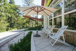 a group of chairs and an umbrella on a patio at Hotel Rural Misarela in Sidros