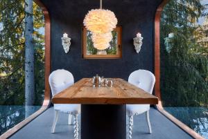 una sala da pranzo con tavolo in legno e sedie bianche di Mi Chalet a La Villa