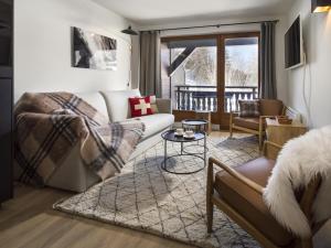 uma sala de estar com um sofá e uma mesa em La Résidence de L'Ours em Megève