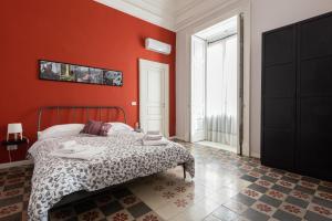 1 dormitorio con paredes rojas y 1 cama. en Casette Umberto, en Catania