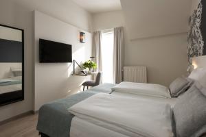 a hotel room with a bed and a television at Martin's Brugge in Bruges