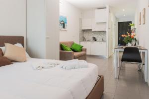 um quarto com uma cama branca e uma cozinha em RESIDENCE LA FILANDA em Lancenigo