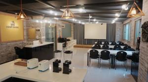 une salle de conférence avec une table et des chaises noires dans l'établissement Sh Guesthouse, à Chuncheon