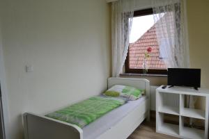 a small bedroom with a bed and a window at Pension Highway Bünde in Bünde