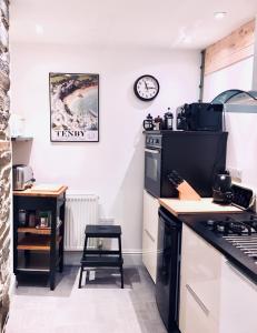 cocina con fogones y reloj en la pared en The Garden Room Apartment, en Cardigan