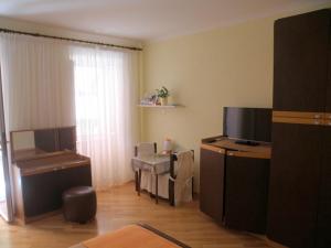 a living room with a desk and a tv in a room at Rooms Alida in Opatija