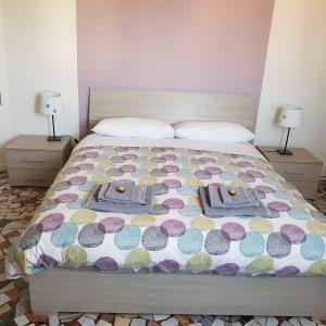 a bed with a colorful bedspread and two lamps at Il Cantuccio B&B in Bologna