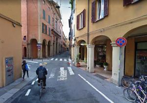 a person riding a bike down a city street at Hostel Il Nosadillo - Bologna in Bologna