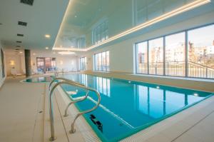 a large swimming pool in a large building at Fitness Apartment - Spa Sauna & Gym by Grand Apartments in Gdańsk